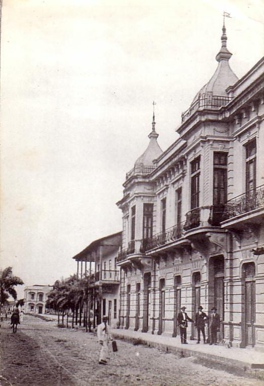 Historic photo of a museum, with dirt lined roads and a horse in the street.