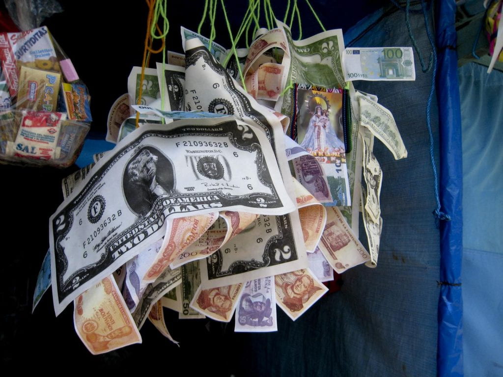 Miniature dollar bills mingle with Bolivianos in the traditional Bolivian alasitas festival.