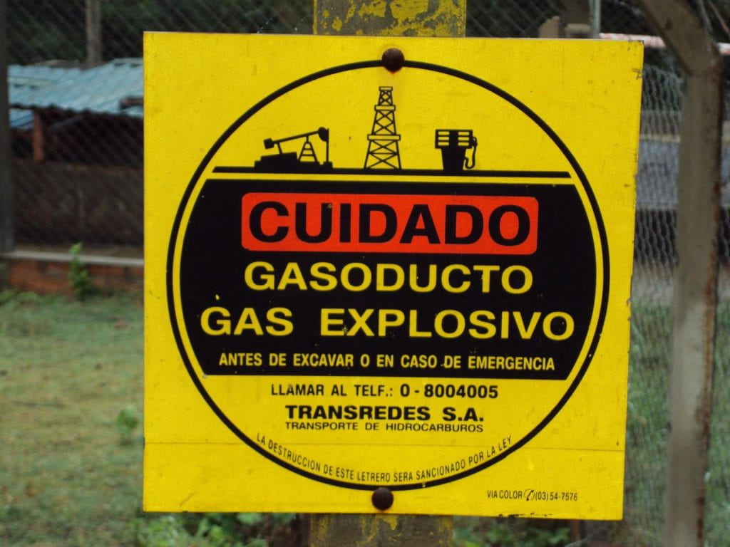 A yellow warning sign, with the words WARNING in red, warning of ex[plosive gases.