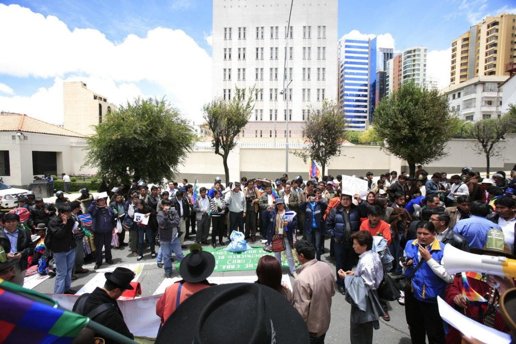 Photo of people gathered around in a circle at a protest.
