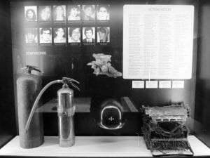 Display from the new Museum for Independence, which honors victims of the conflict in its hot spot project. The display shows photos of victims, a list of victims, and artifacts that symbolize their lives--a typewriter, a fire extinguisher, a helmet.