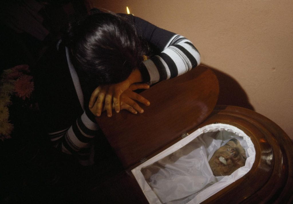 A woman cries at the casket during the wake for Hector Gomez Calito, founding member of Mutual Support Group for the Families of the Disappeared (GAM), Amatitlán, 1985.