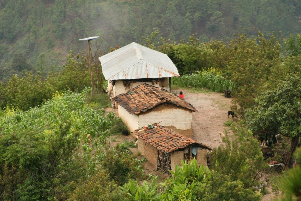 Cluster of mud huts with solar panels.